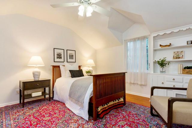 a front view of a house with garden and trees