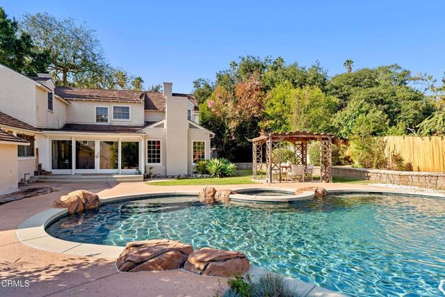 a view of a swimming pool with a yard and trees