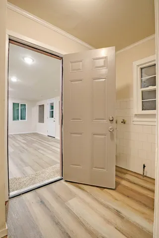 an empty room with wooden floor and cabinet