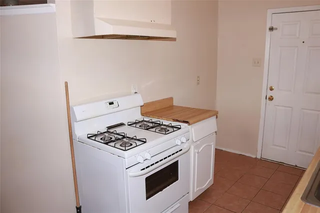 a white stove top oven sitting inside of a kitchen