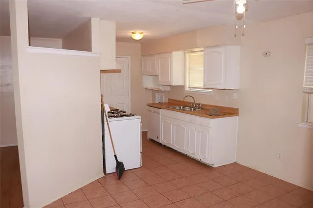 a kitchen with white cabinets and white appliances
