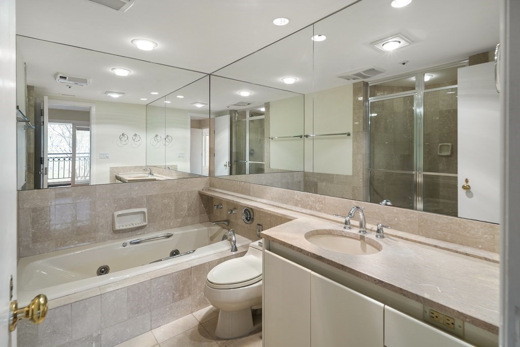 20 Rowes Wharf, Unit 503 Boston, MA 02110 - Photo 24 of 26 a bathroom with a granite countertop sink a toilet a mirror and shower