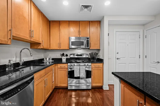 a kitchen with stainless steel appliances granite countertop a stove and a sink