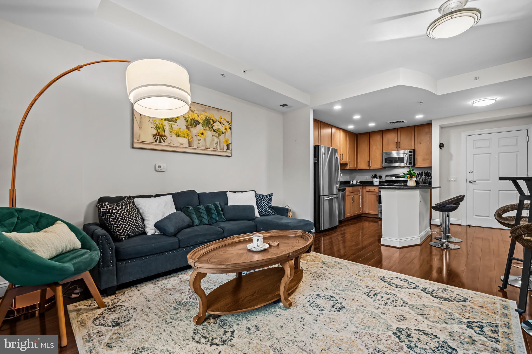 1111 Oronoco Street, Unit 326 Alexandria, VA 22314 - Photo 14 of 54 a living room with stainless steel appliances kitchen island granite countertop a couch and wooden floor