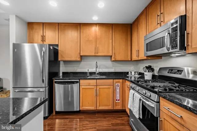 a kitchen with stainless steel appliances granite countertop a refrigerator stove and sink