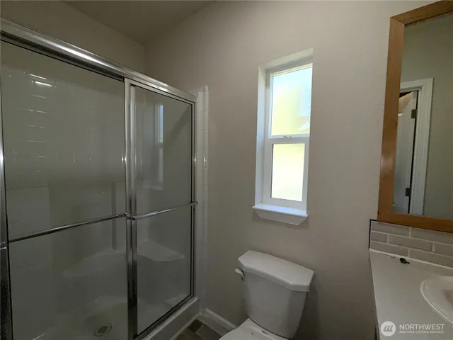 a bathroom with a shower a toilet and sink