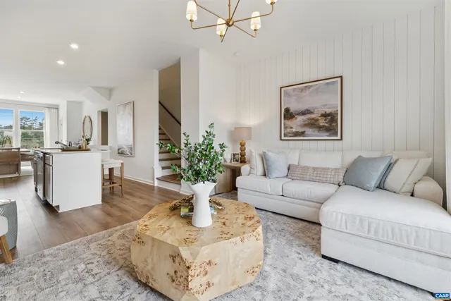 a living room with furniture a fireplace and a chandelier