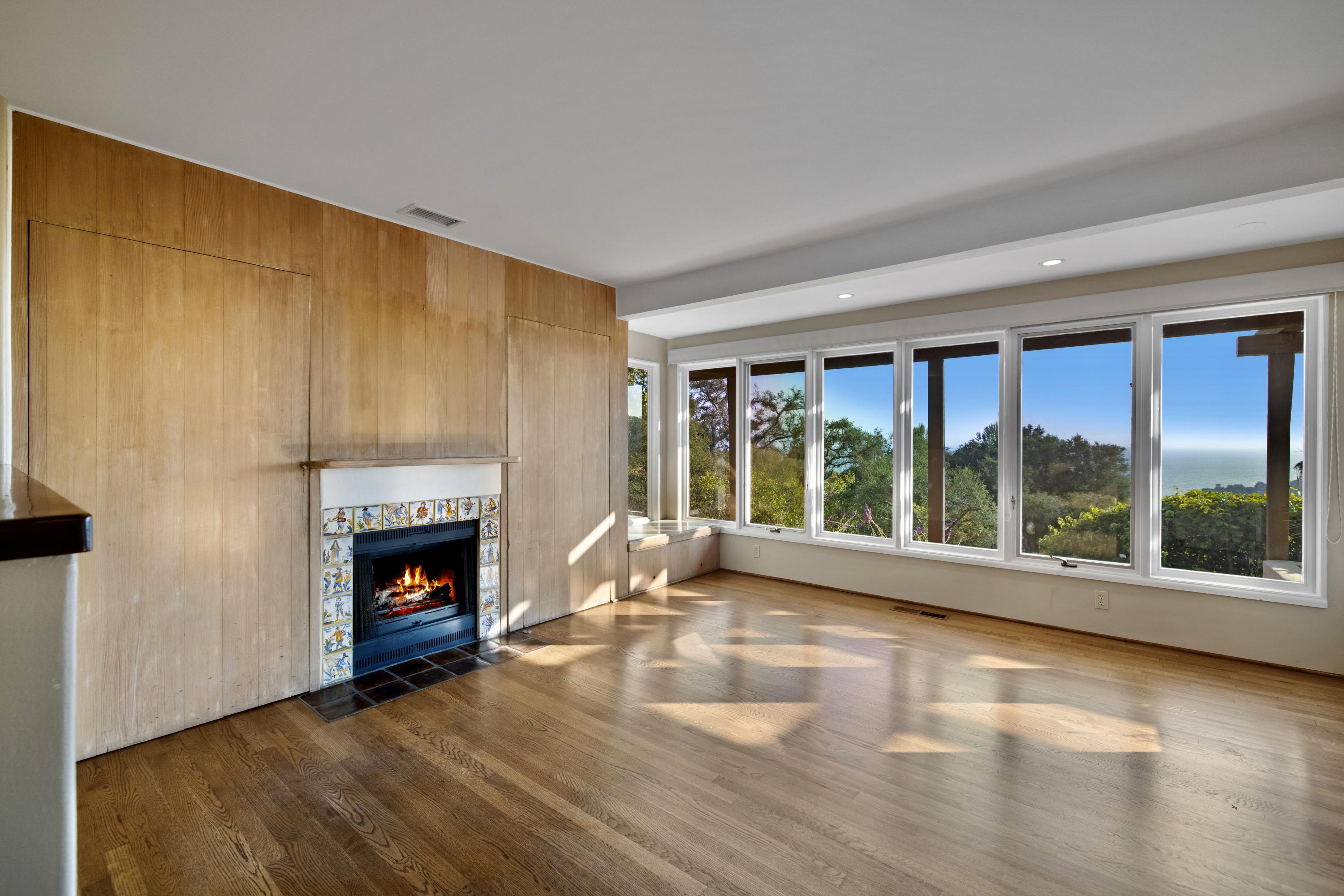 1986 Arriba Street Carpinteria, CA 93013 - Photo 12 of 27 a living room with fireplace and a floor to ceiling window
