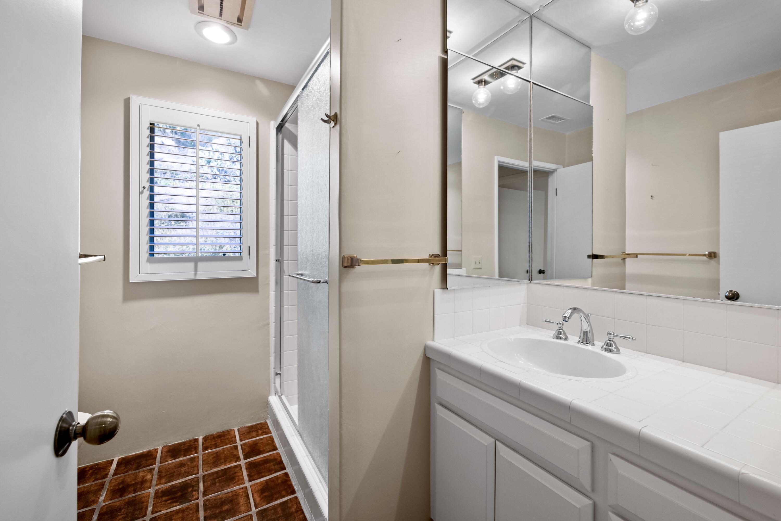 1986 Arriba Street Carpinteria, CA 93013 - Photo 19 of 27 a bathroom with a sink a mirror a vanity and a shower