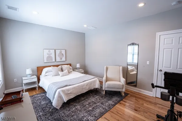 a bedroom with a bed wooden floor and lamp