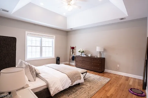 a spacious bedroom with a bed and wooden floor