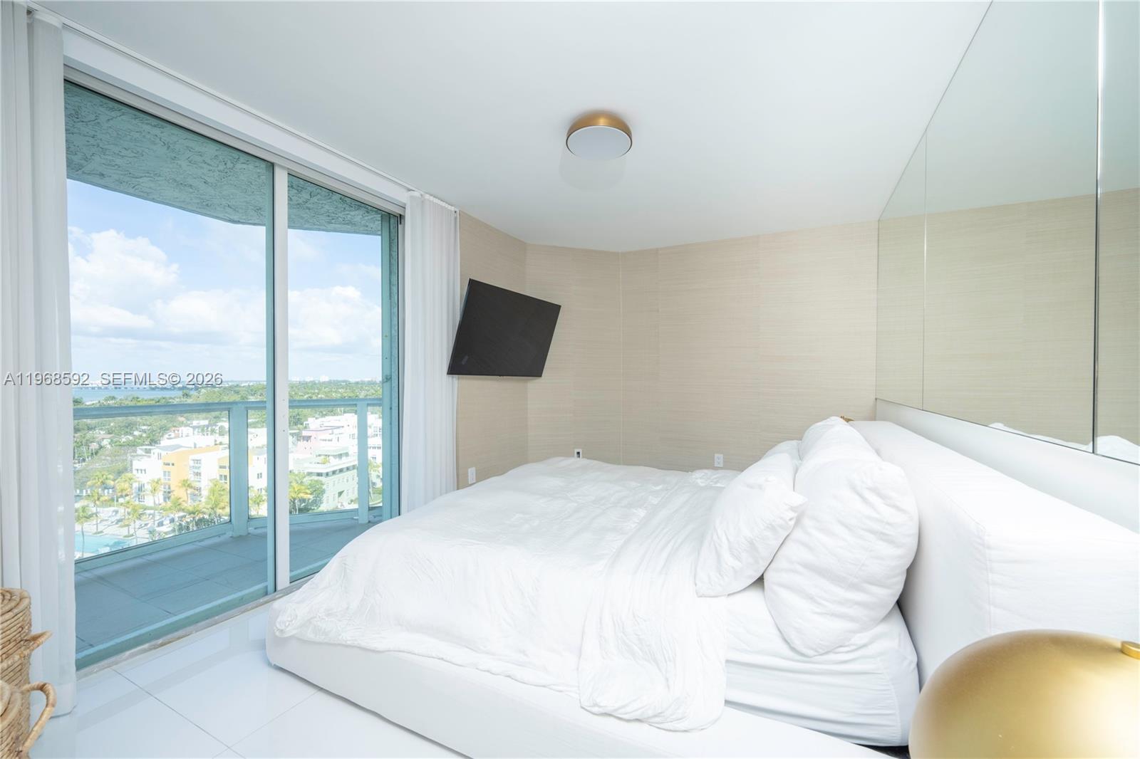 5900 Collins Avenue, Unit 1401 Miami Beach, FL 33140 - Photo 24 of 51 a bed sitting in a bedroom next to a window