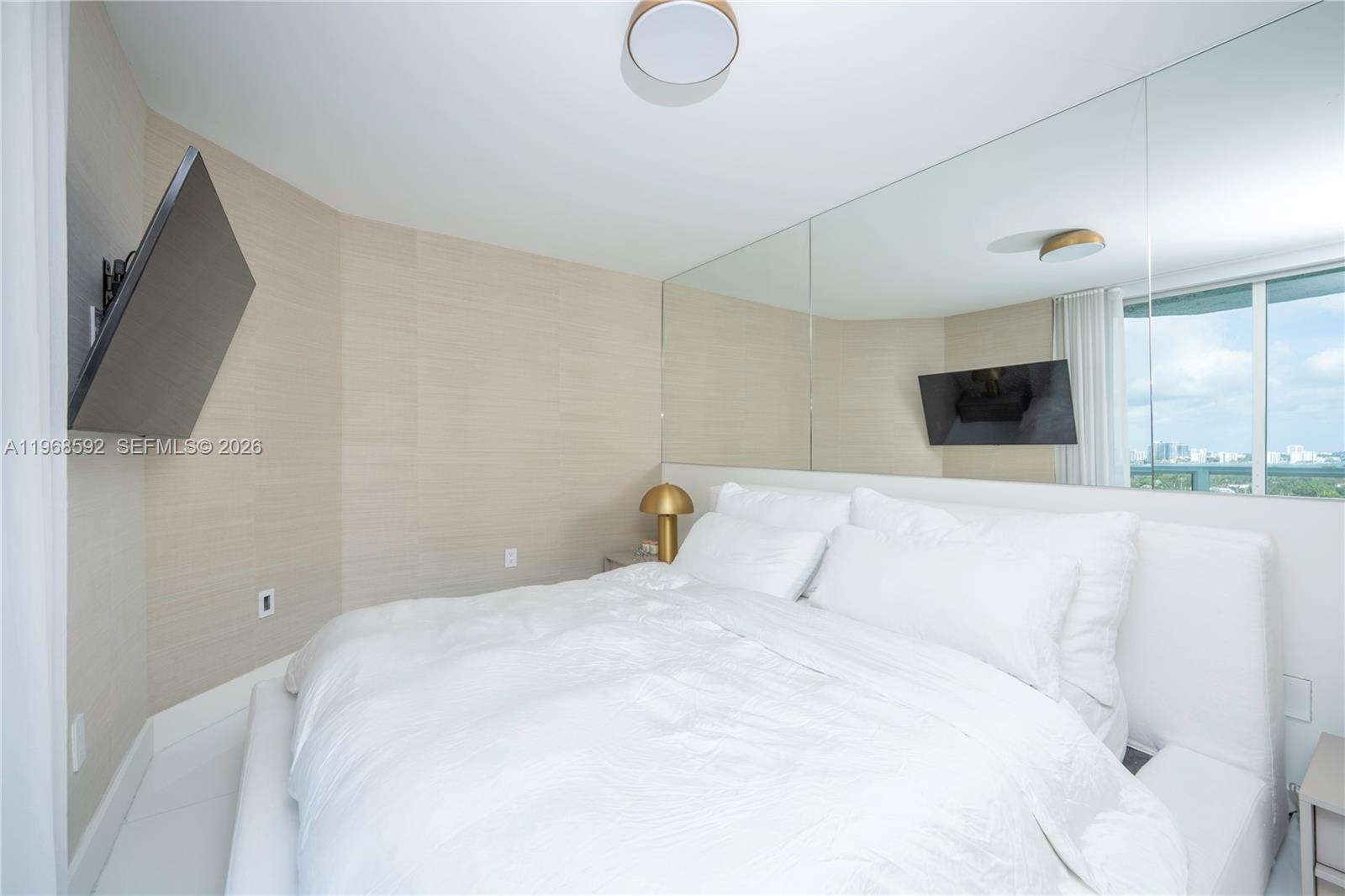 5900 Collins Avenue, Unit 1401 Miami Beach, FL 33140 - Photo 25 of 51 a bedroom with a large bed and a flat screen tv