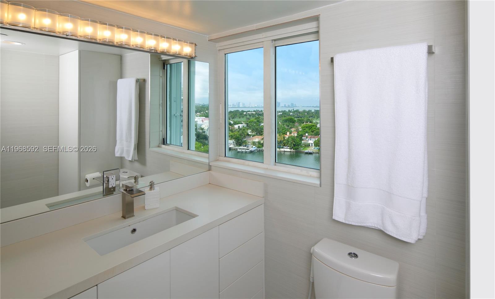 5900 Collins Avenue, Unit 1401 Miami Beach, FL 33140 - Photo 28 of 51 a bathroom with a sink a toilet and a mirror