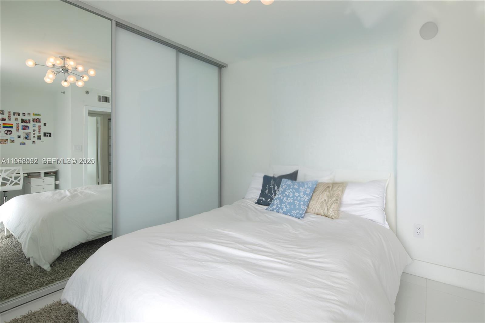 5900 Collins Avenue, Unit 1401 Miami Beach, FL 33140 - Photo 32 of 51 a bedroom with a bed and a chandelier