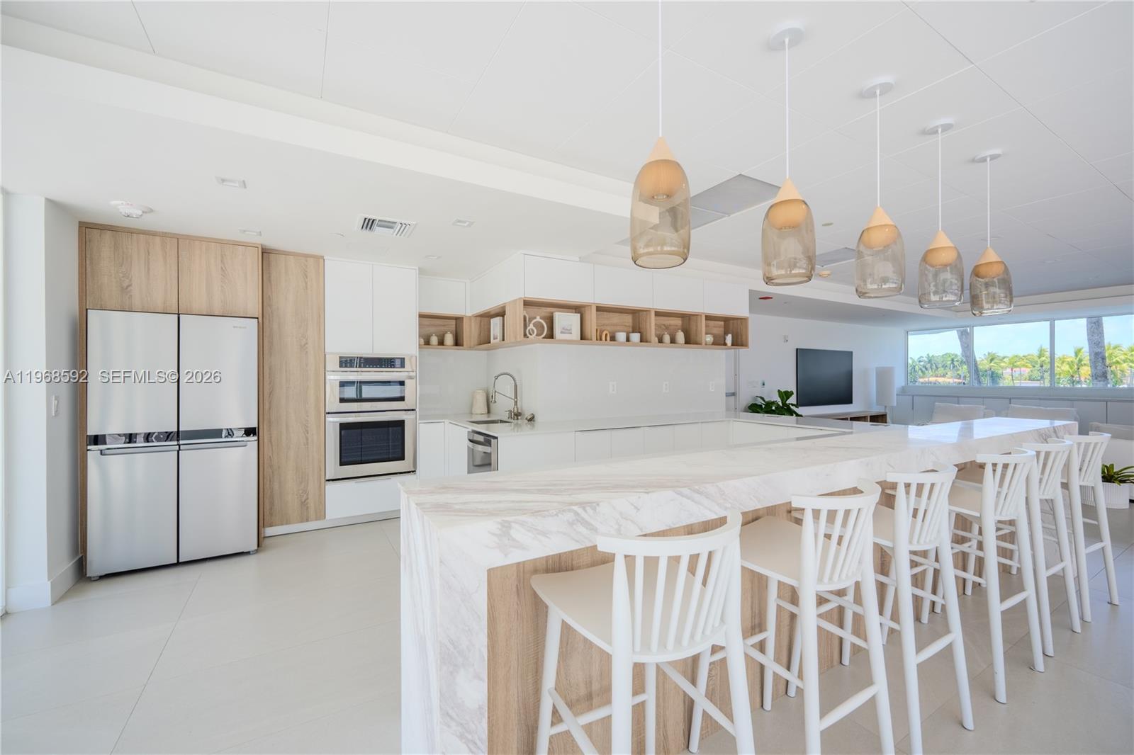 5900 Collins Avenue, Unit 1401 Miami Beach, FL 33140 - Photo 45 of 51 a kitchen with kitchen island a stove a sink and a refrigerator