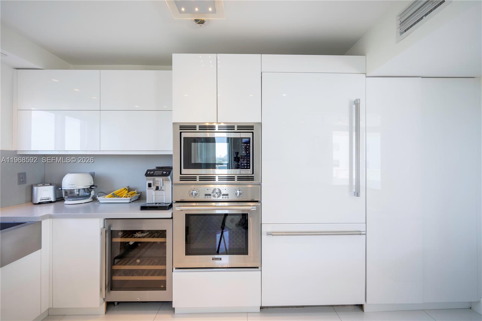 5900 Collins Avenue, Unit 1401 Miami Beach, FL 33140 - Photo 6 of 51 a kitchen with stainless steel appliances a stove a microwave and a refrigerator