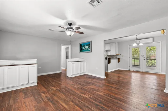 a view of empty room with wooden floor and window