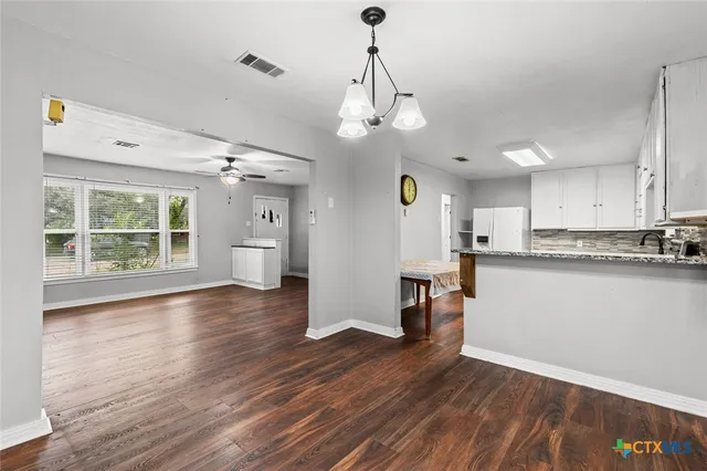 a view of a kitchen with wooden floor and a window