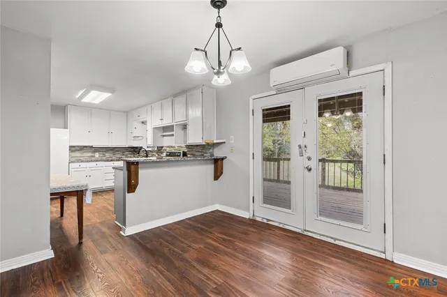 a view of a kitchen with wooden floor and a refrigerator