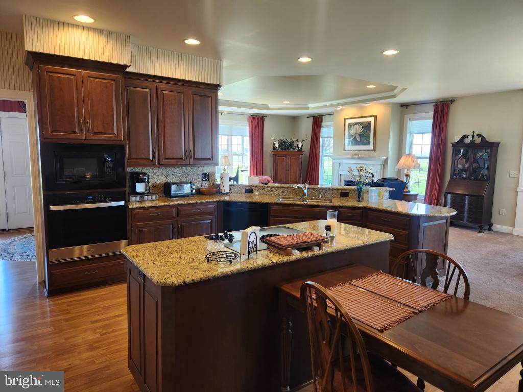 1043 Spring Valley Road Quarryville, PA 17566 - Photo 31 of 79 a kitchen with a stove a sink a kitchen island and chairs