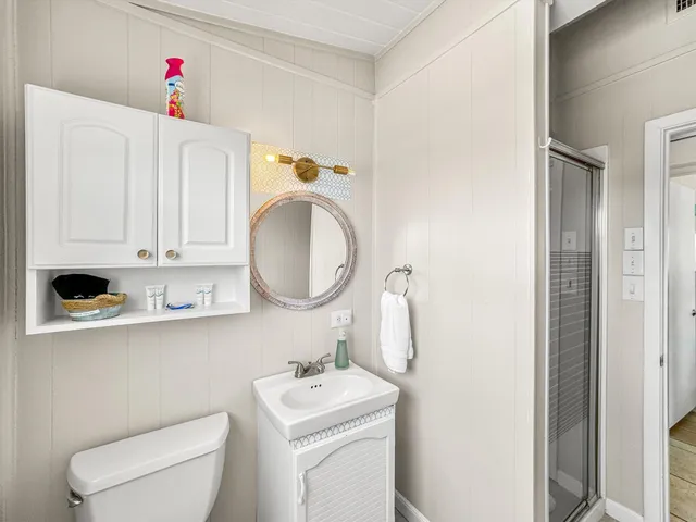 a bathroom with a sink a toilet and a mirror