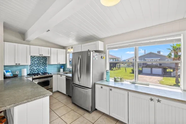 a kitchen with a refrigerator a stove a sink and dishwasher with wooden floor