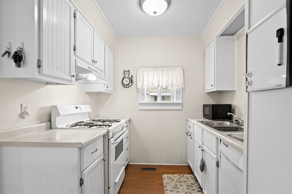 58 Bally Drive Raynham, MA 02767 - Photo 2 of 9 a kitchen with stainless steel appliances a stove a sink and a microwave