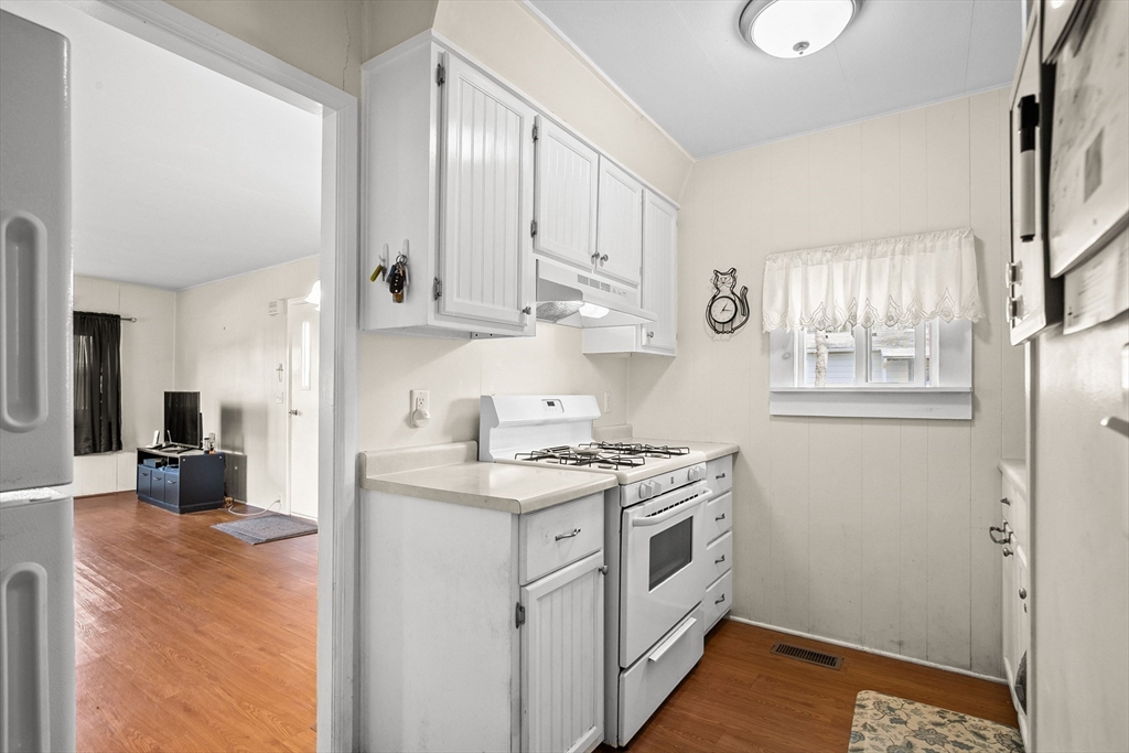 58 Bally Drive Raynham, MA 02767 - Photo 3 of 9 a kitchen with stainless steel appliances granite countertop a stove a sink and white cabinets