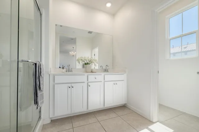 a spacious bathroom with a shower a sink and a mirror