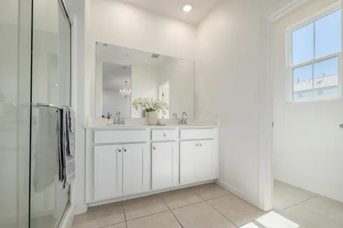 a spacious bathroom with a shower a sink and a mirror