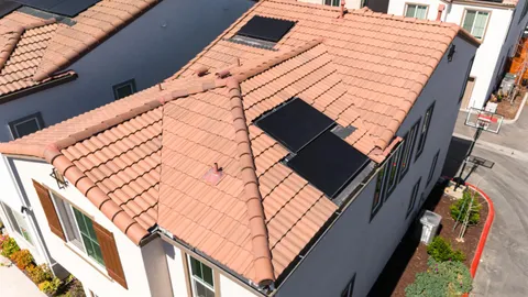 an aerial view of a house with a garden and lake view