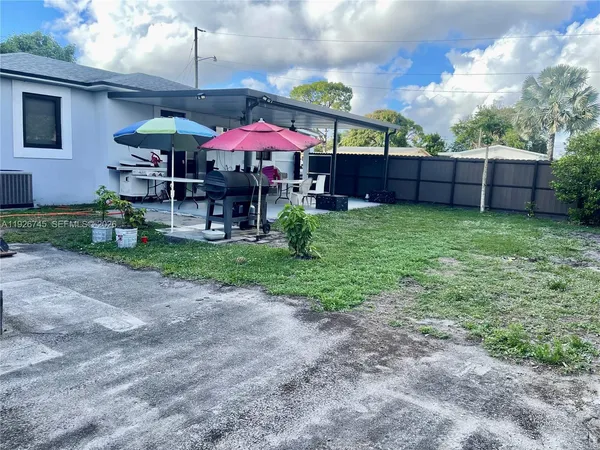 a backyard of a house with table and chairs