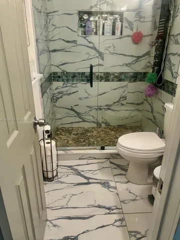 a bathroom with a toilet and a shower