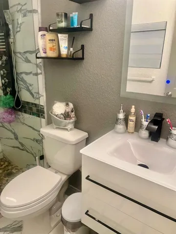a bathroom with a sink a toilet and a mirror