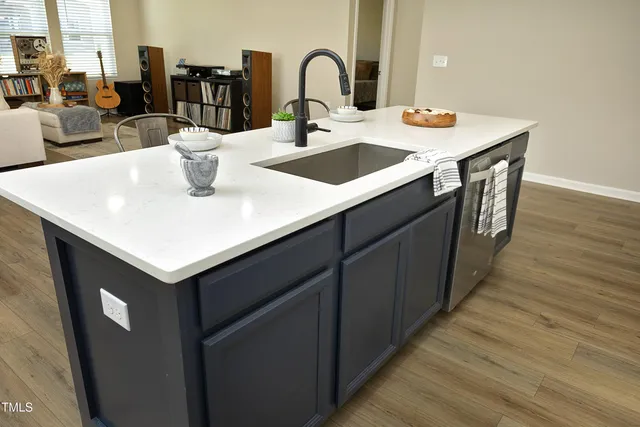 a kitchen with a sink and a wooden floor