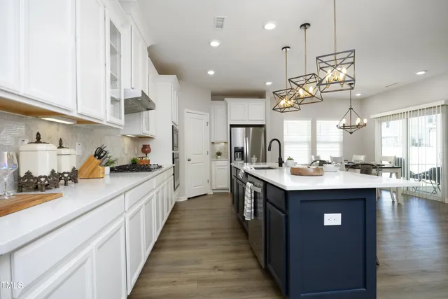 a kitchen with kitchen island a sink appliances and cabinets