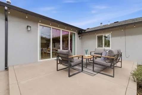 a backyard of a house with table and chairs