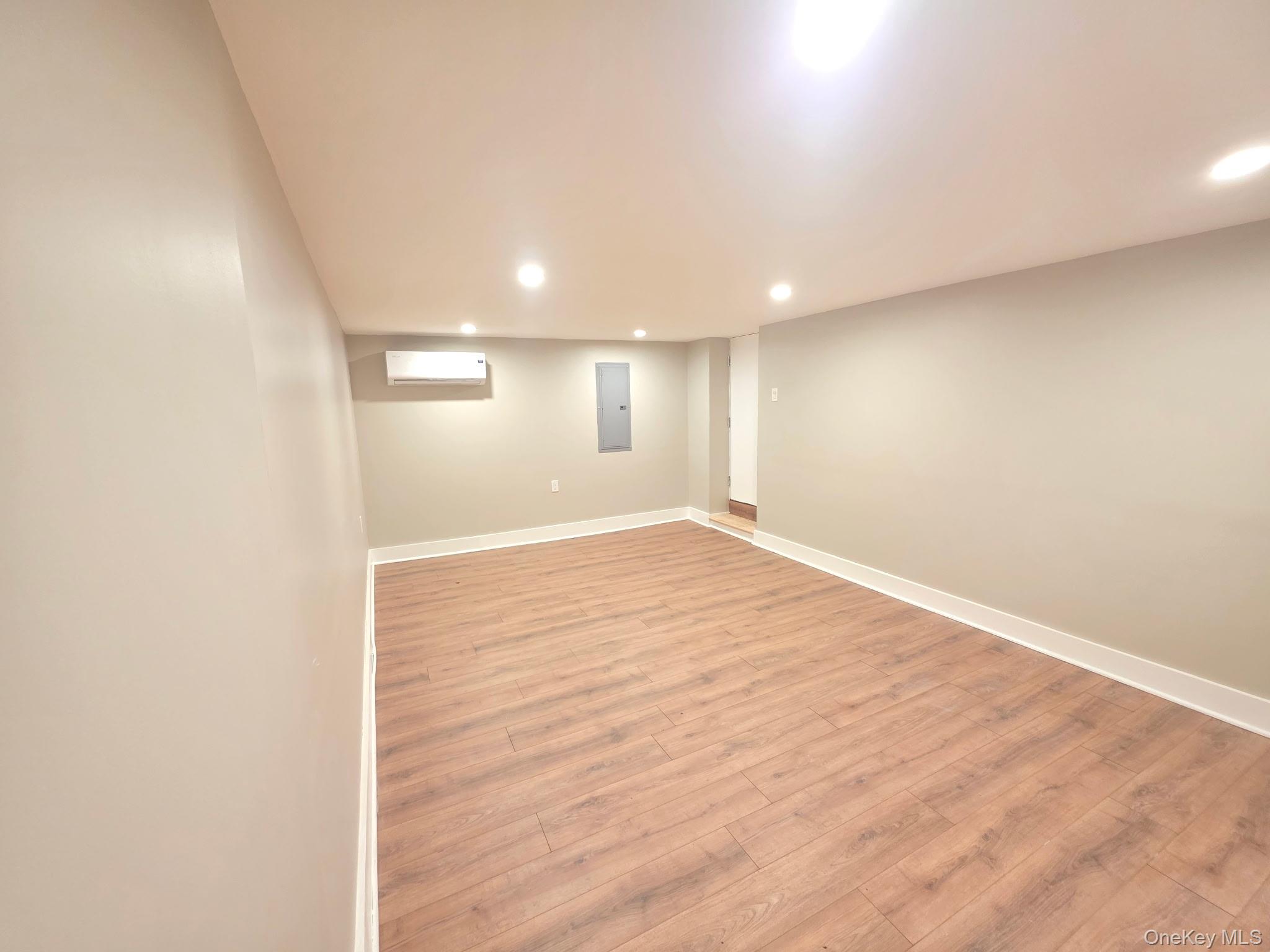 263 South Mountain Road New City, NY 10956 - Photo 27 of 33 Finished below grade area featuring recessed lighting, light wood finished floors, electric panel, and a wall unit AC