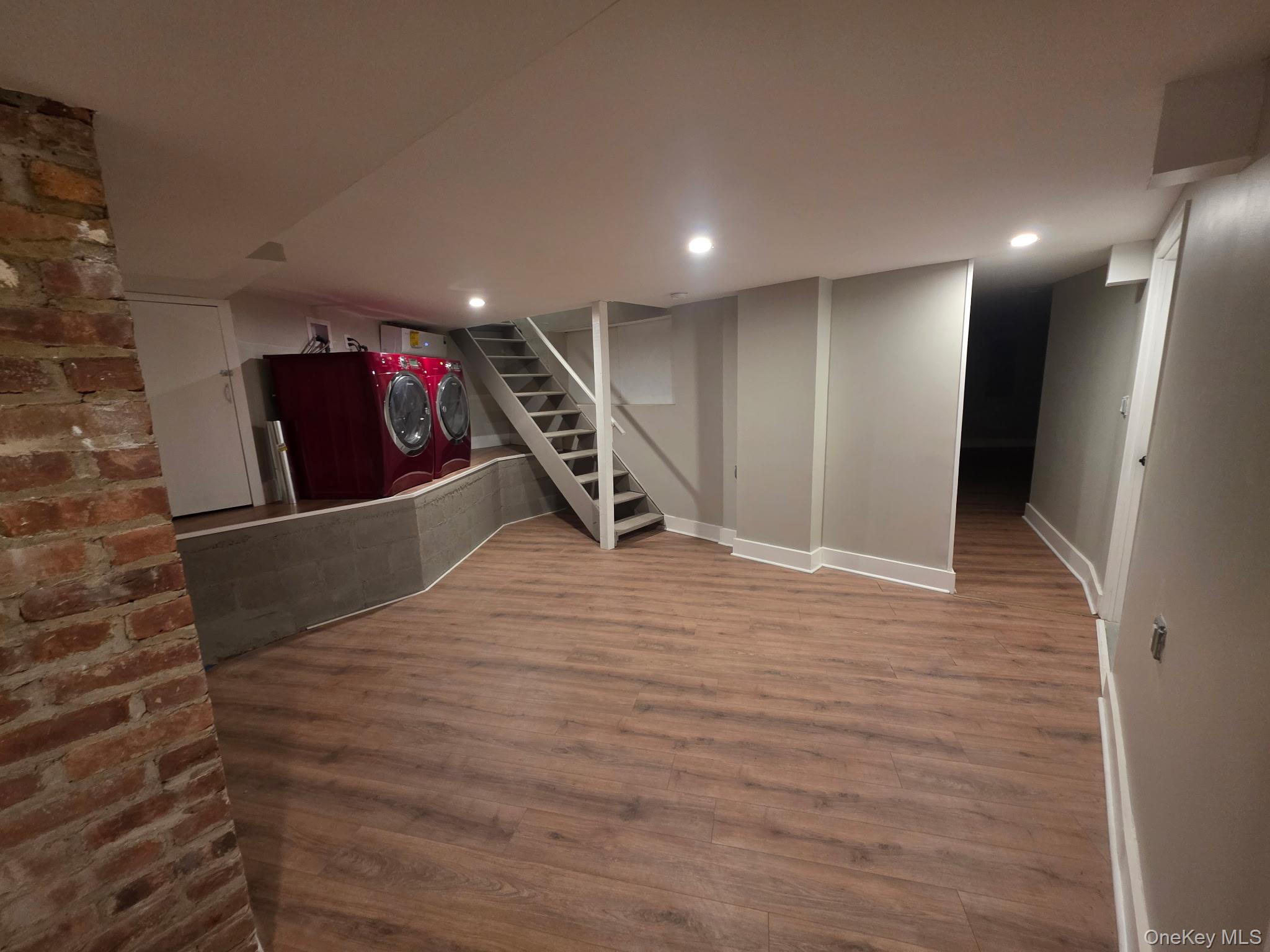 263 South Mountain Road New City, NY 10956 - Photo 31 of 33 Finished basement featuring wood finished floors, stairway, brick wall, separate washer and dryer, and recessed lighting