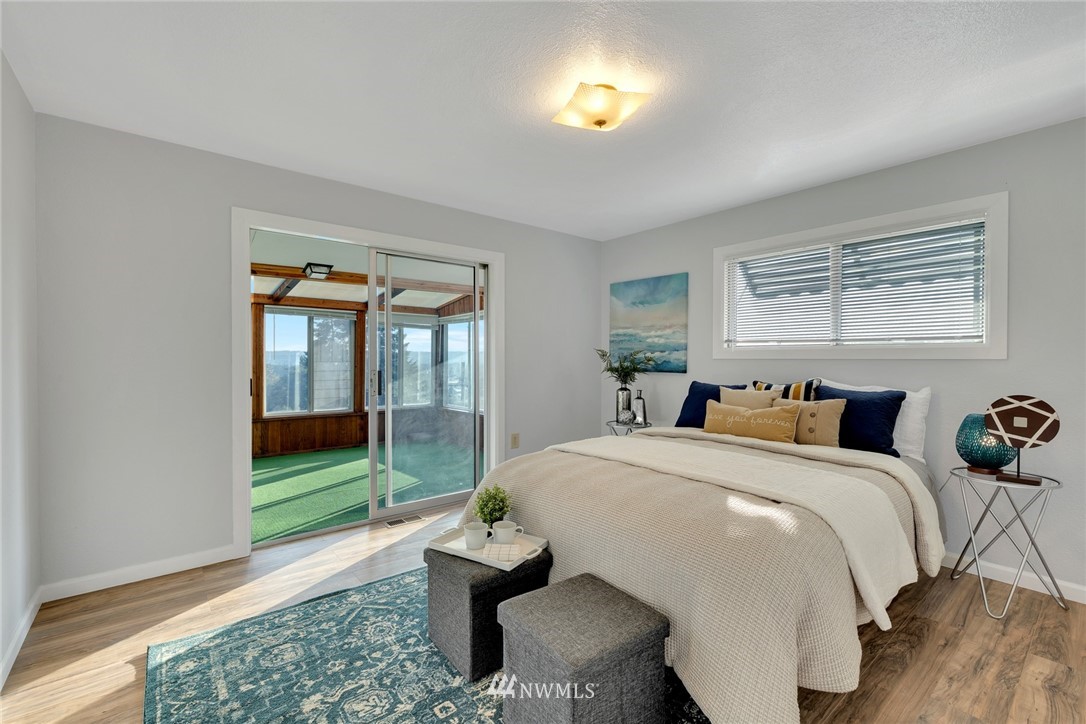 11409 Karshner Road East Edgewood, WA 98372 - Photo 8 of 28 a bed room with a bed and a view of en suite bathroom
