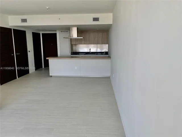a kitchen with kitchen island a counter top space and stainless steel appliances