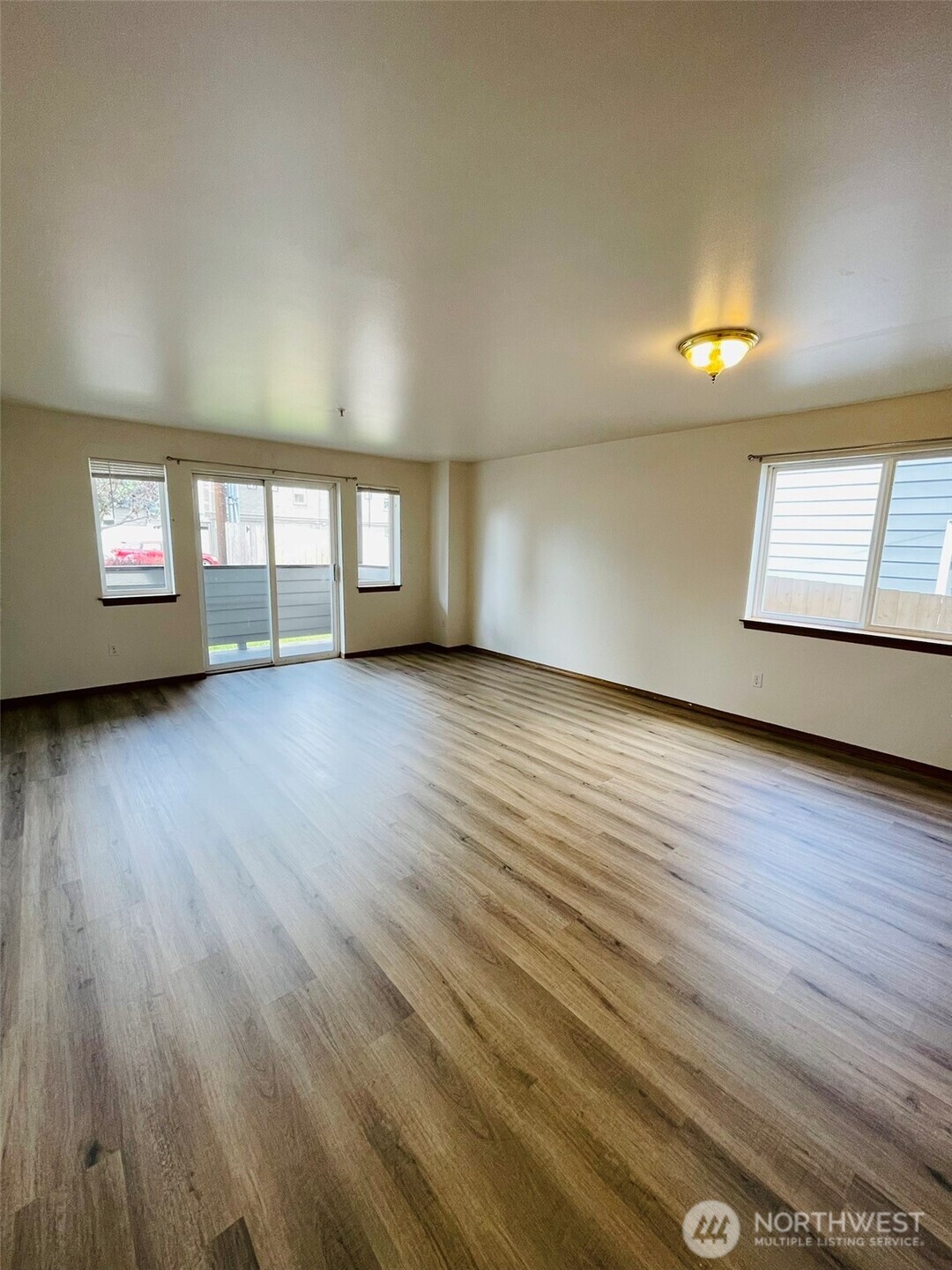 8830 Nesbit Avenue North Seattle, WA 98103 - Photo 18 of 32 an empty room with wooden floor and windows