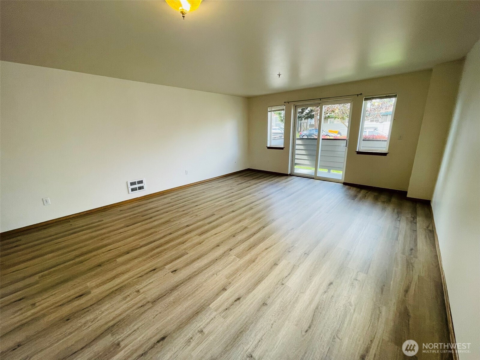 8830 Nesbit Avenue North Seattle, WA 98103 - Photo 19 of 32 an empty room with wooden floor and windows