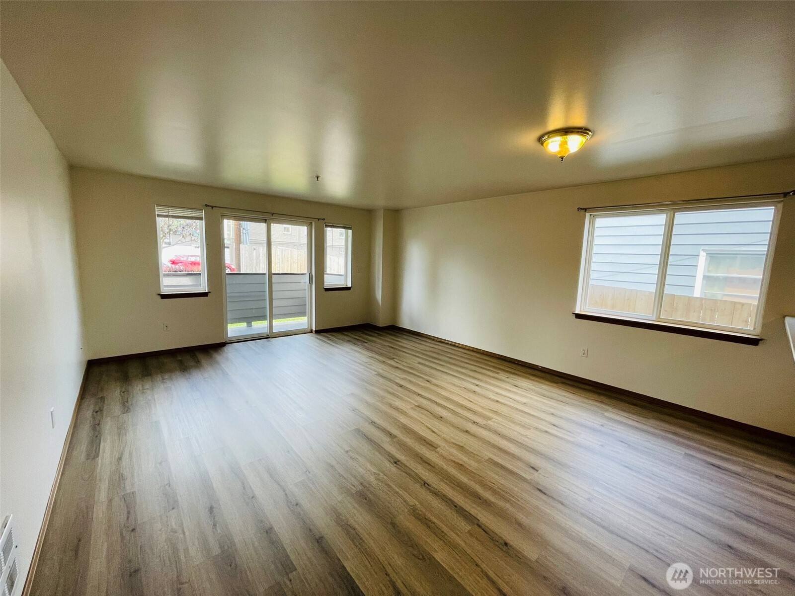 8830 Nesbit Avenue North Seattle, WA 98103 - Photo 20 of 32 an empty room with wooden floor and windows