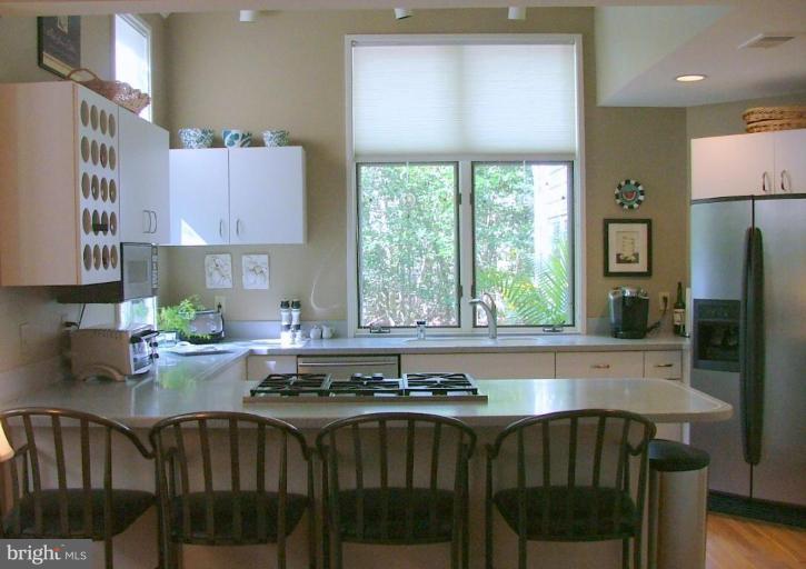 11591 Greenwich Point Road Reston, VA 20194 - Photo 7 of 30 a kitchen with a table chairs stove and cabinets
