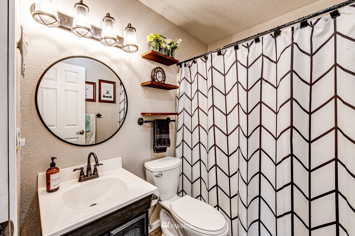 155 Taylor Cutoff Road Sequim, WA 98382 - Photo 14 of 37 a bathroom with a sink vanity mirror and toilet