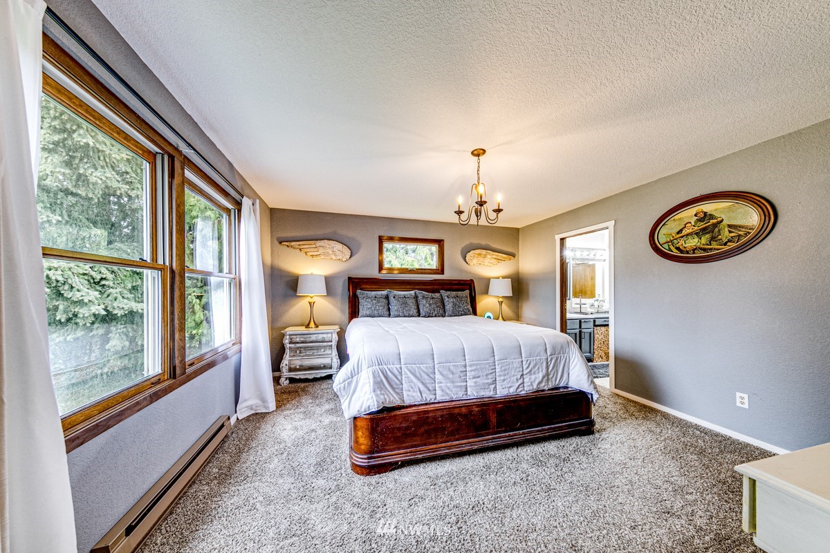 155 Taylor Cutoff Road Sequim, WA 98382 - Photo 16 of 37 a spacious bedroom with a bed and a large window with outer view