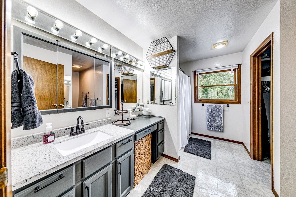 155 Taylor Cutoff Road Sequim, WA 98382 - Photo 17 of 37 a spacious bathroom with a granite countertop sink and a mirror