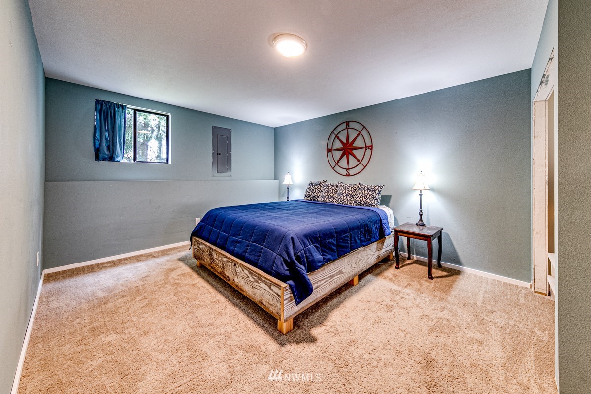 155 Taylor Cutoff Road Sequim, WA 98382 - Photo 20 of 37 a bedroom with a bed and a night stand